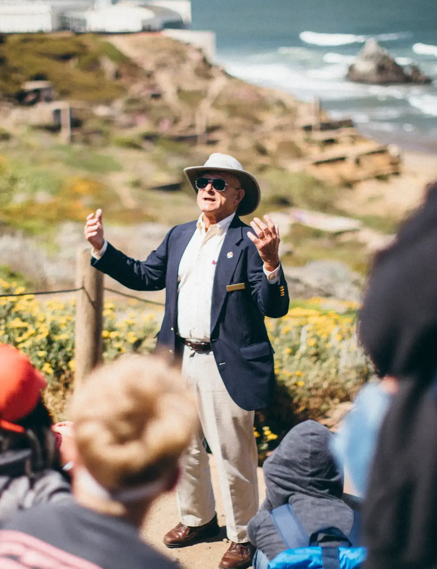 local guide speaking to a group of students near the ocean