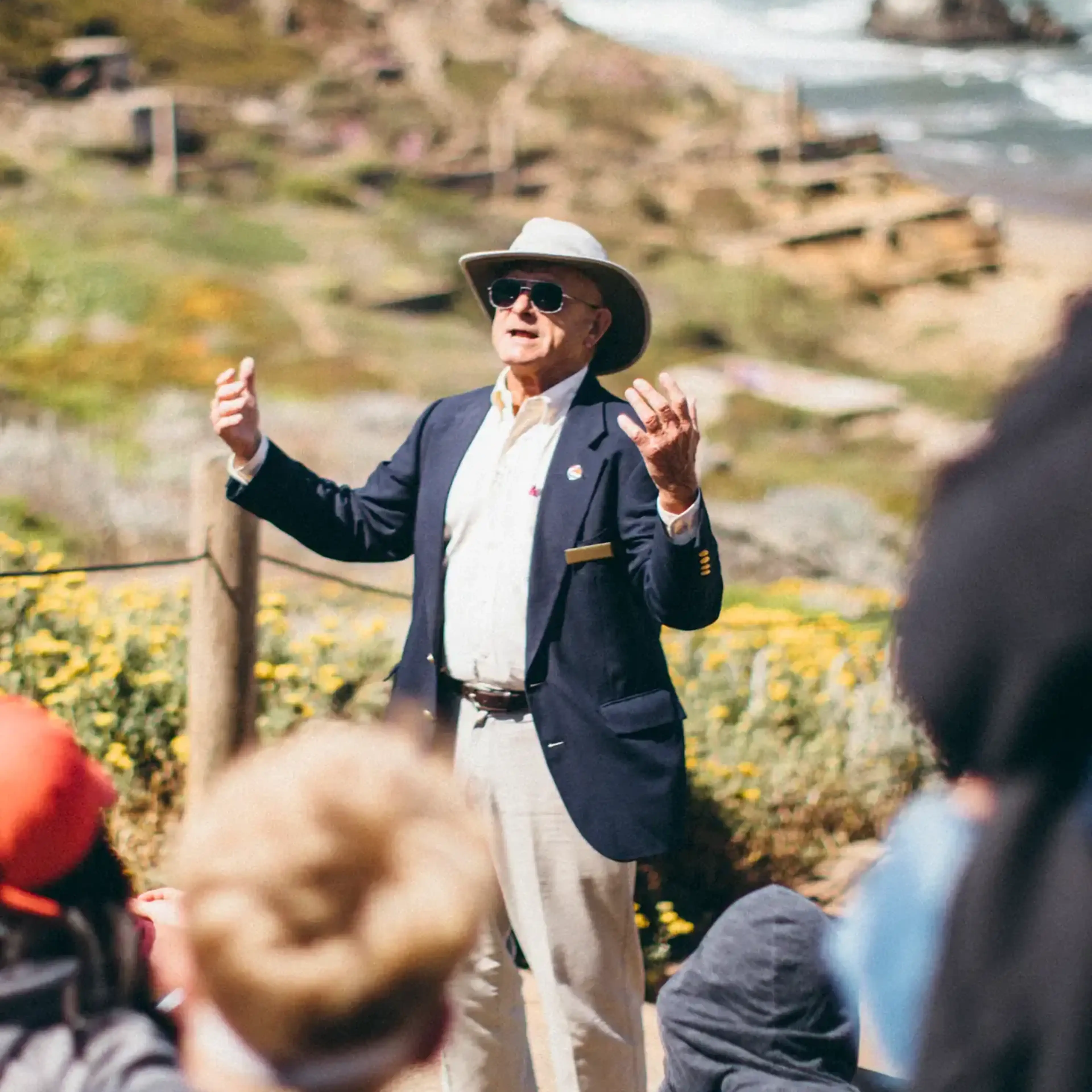 local guide speaking to a group of students near the ocean