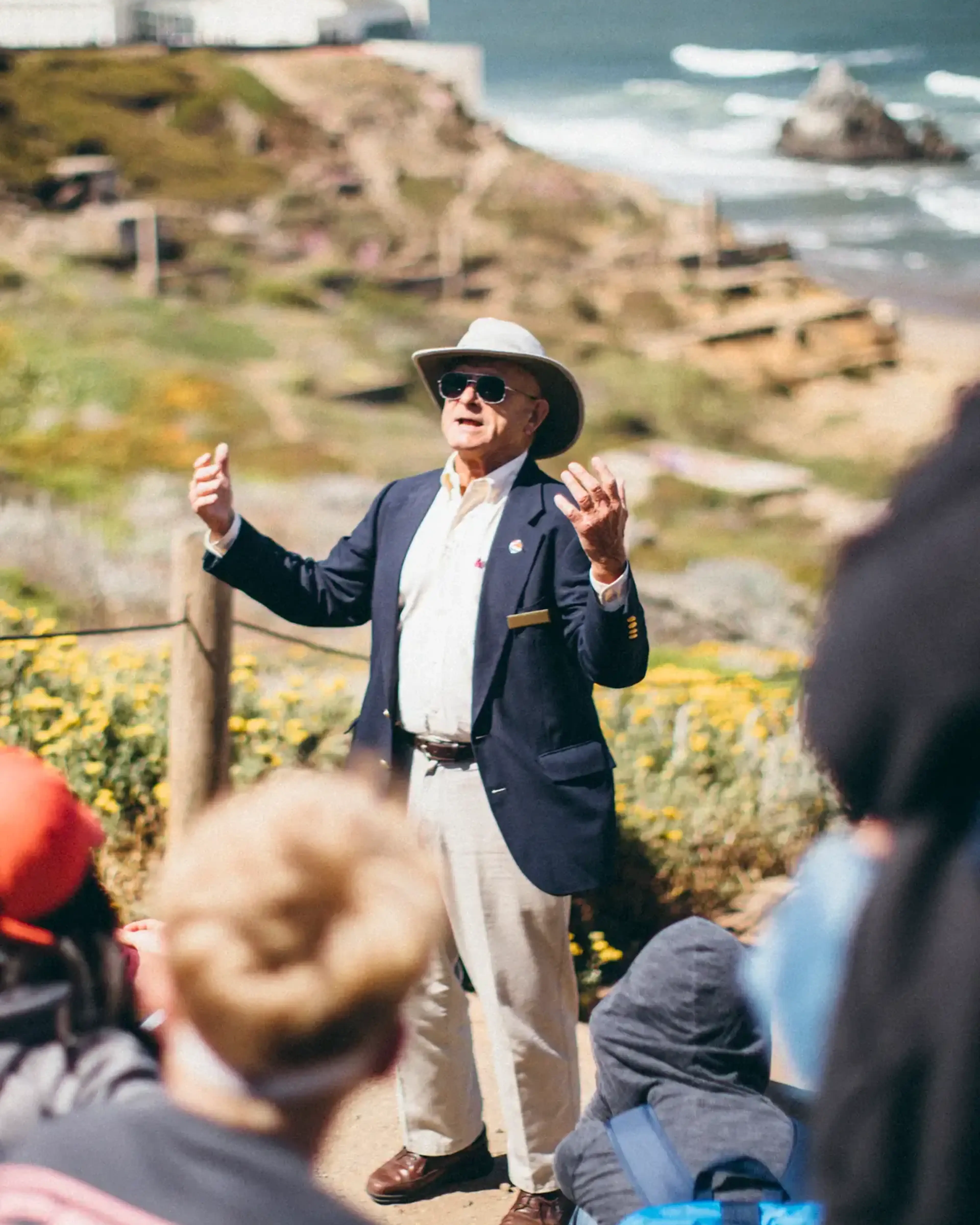 local guide speaking to a group of students near the ocean