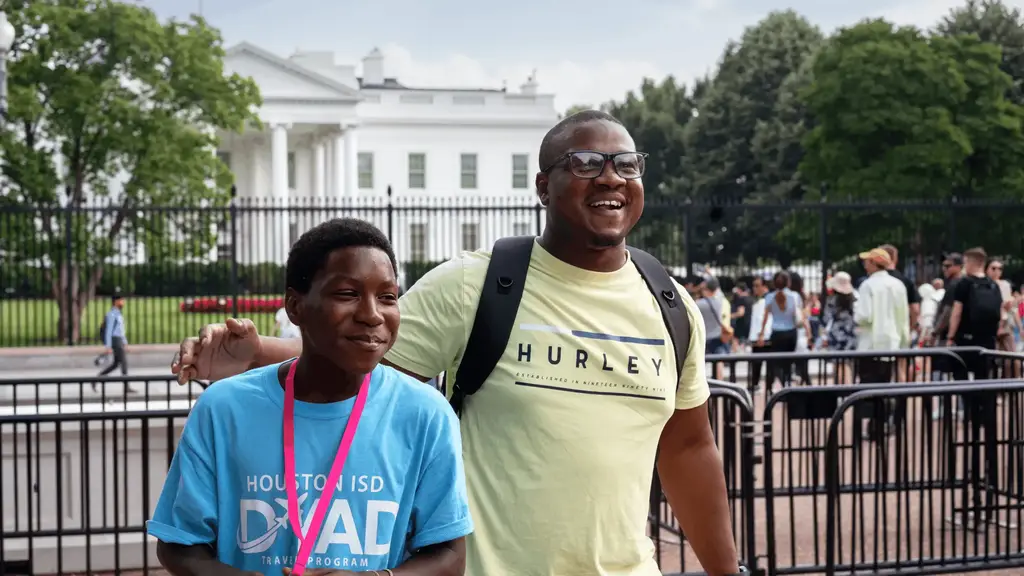 teacher and student posing in front of white house
