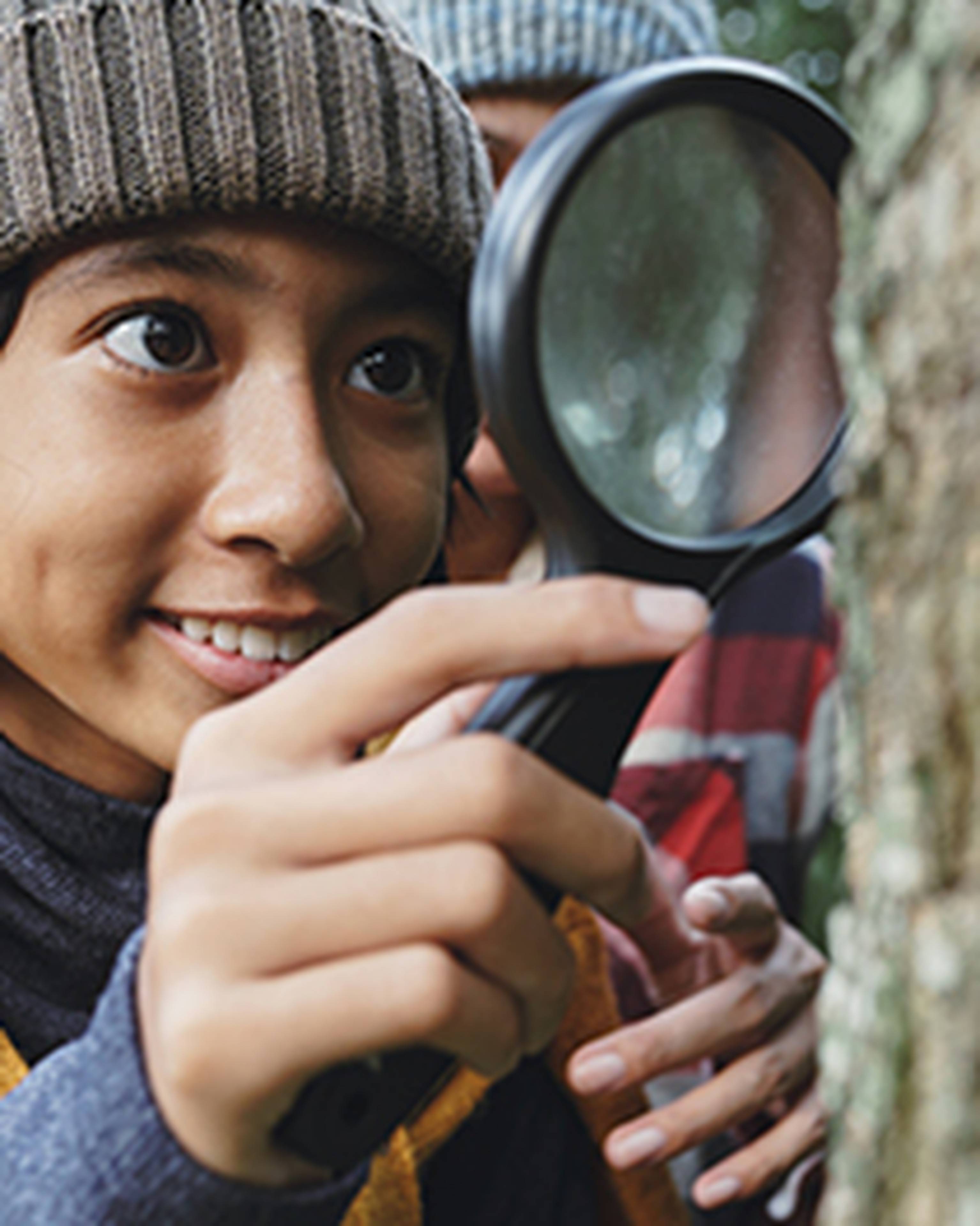 student looking with magnifying glass