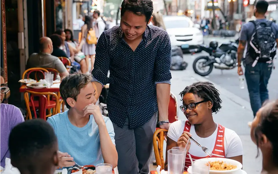 students interacting with local at restaurant