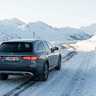 Mercedes-Benz E-Klasse All-Terrain op een besneeuwde bergweg in de Alpen naast een verkeersbord voor verplichte sneeuwkettingen