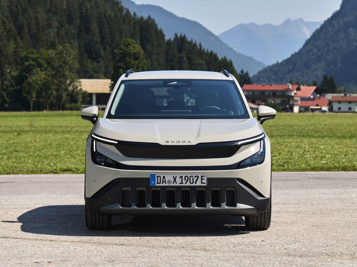 Witte Škoda Epiq van voren gefotografeerd met bergen op de achtergrond