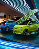 Deux Abarth 500e, bleue et vert acide, sur fond urbain nocturne
