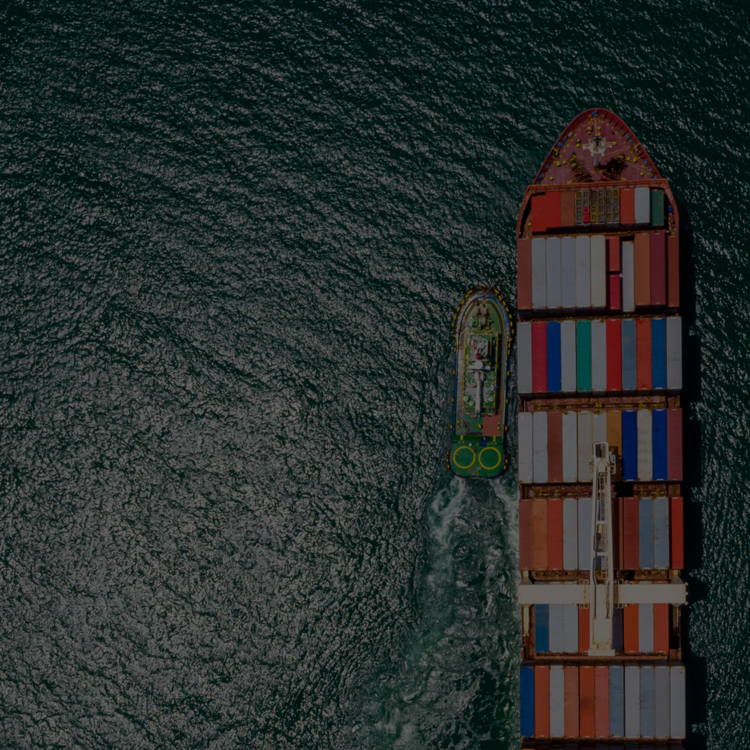 Aerial view of a large cargo ship with a small boat delivering biofuel