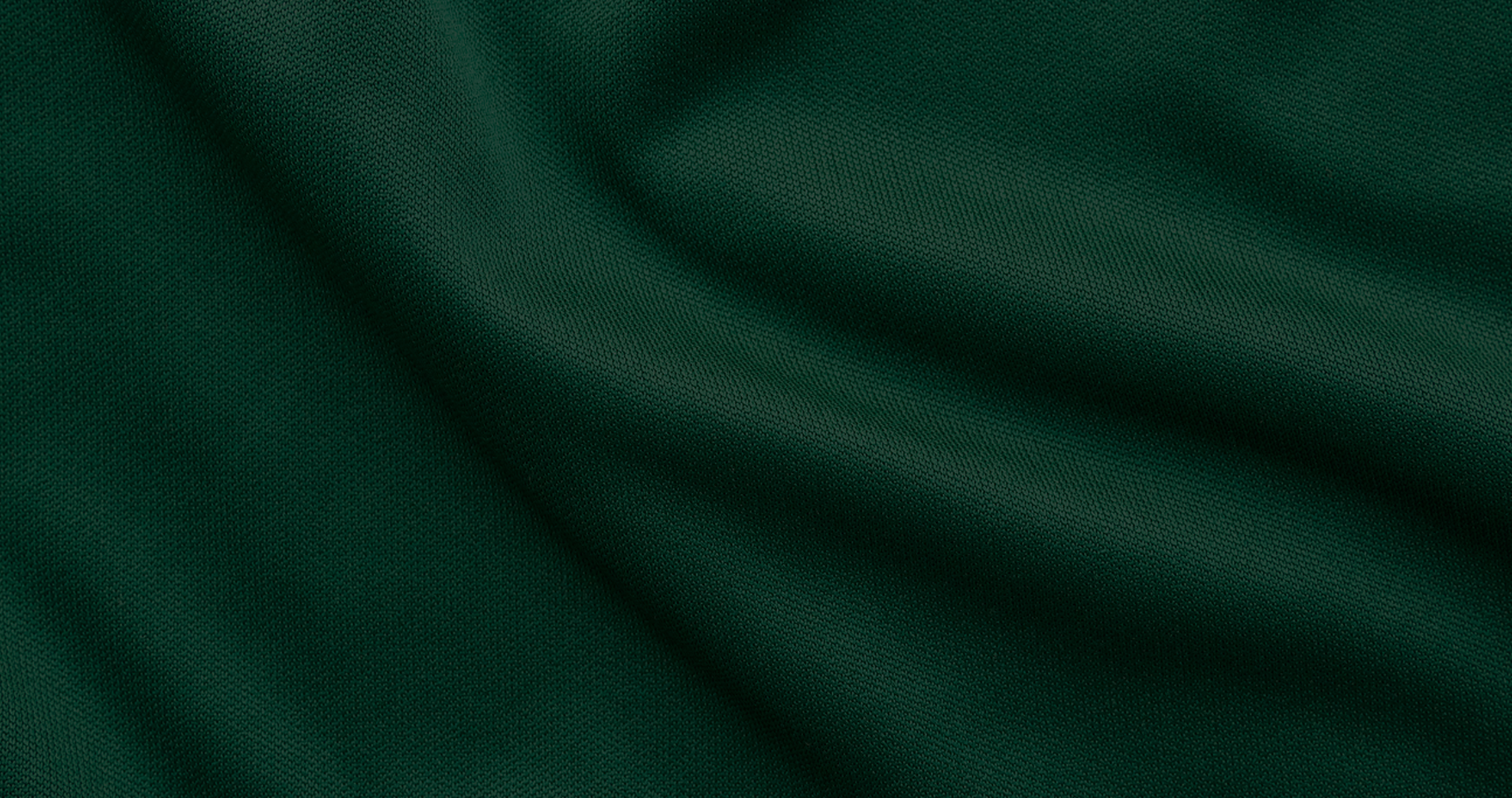 Close-up of a textured, dark green fabric with gentle folds