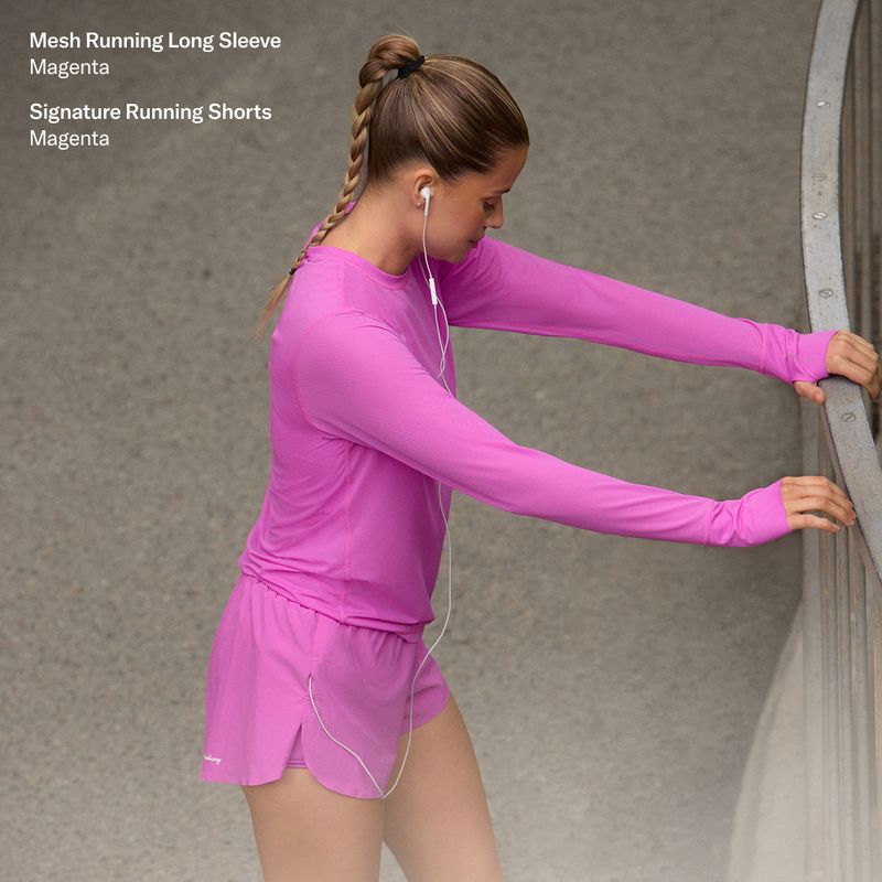 Woman in magenta athletic wear stretches on a railing, wearing earphones. Text on image describes the outfit as mesh running long sleeve and shorts.