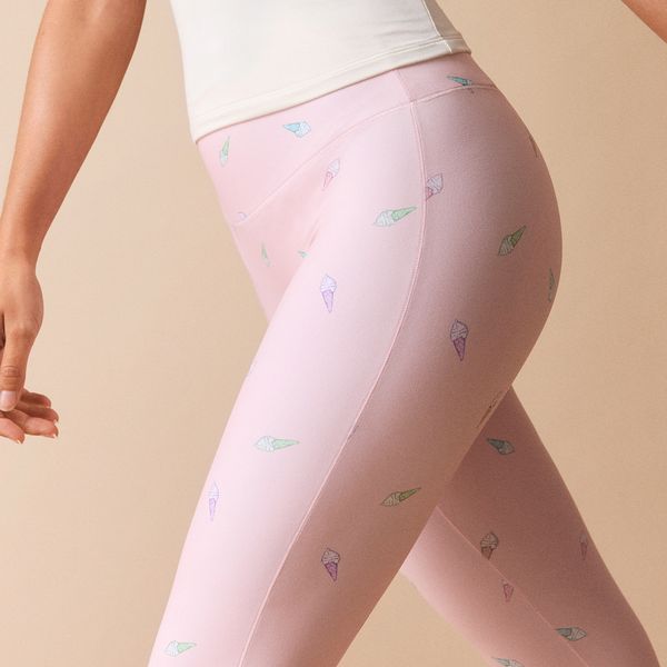 Person wearing pink leggings with small, colorful ice cream cone patterns, paired with a white top.