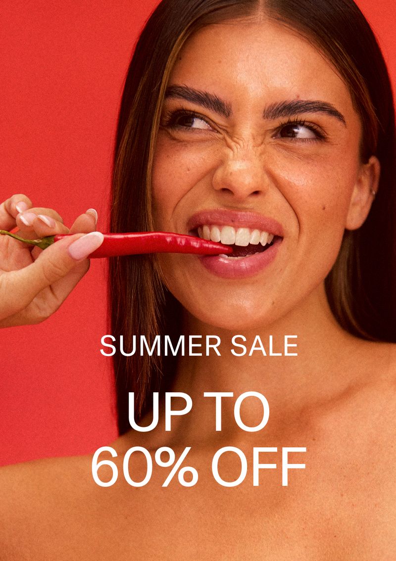 Woman biting a pepper with red backgorund