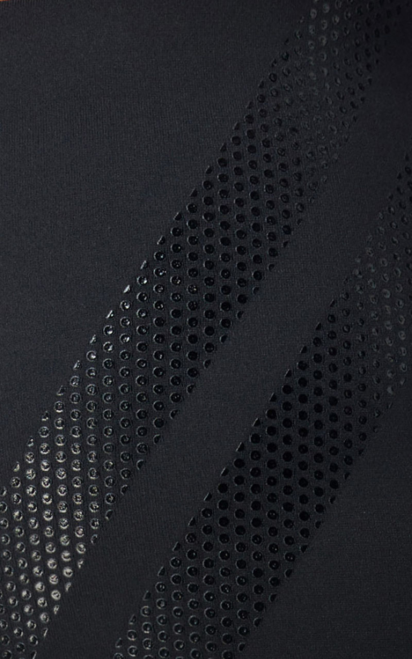 Close-up of black fabric with two diagonal dotted stripes, creating a textured and patterned surface.