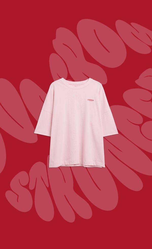 Pink t-shirt with "STRONGER" printed in small letters on a red background with oversized abstract text.