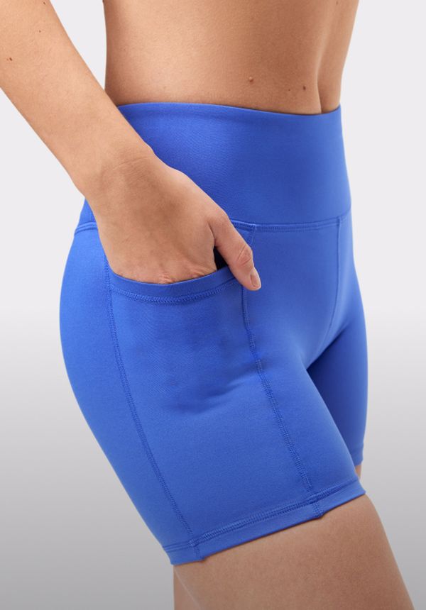 Person wearing bright blue athletic shorts with a high waistband and a hand placed casually in the side pocket.