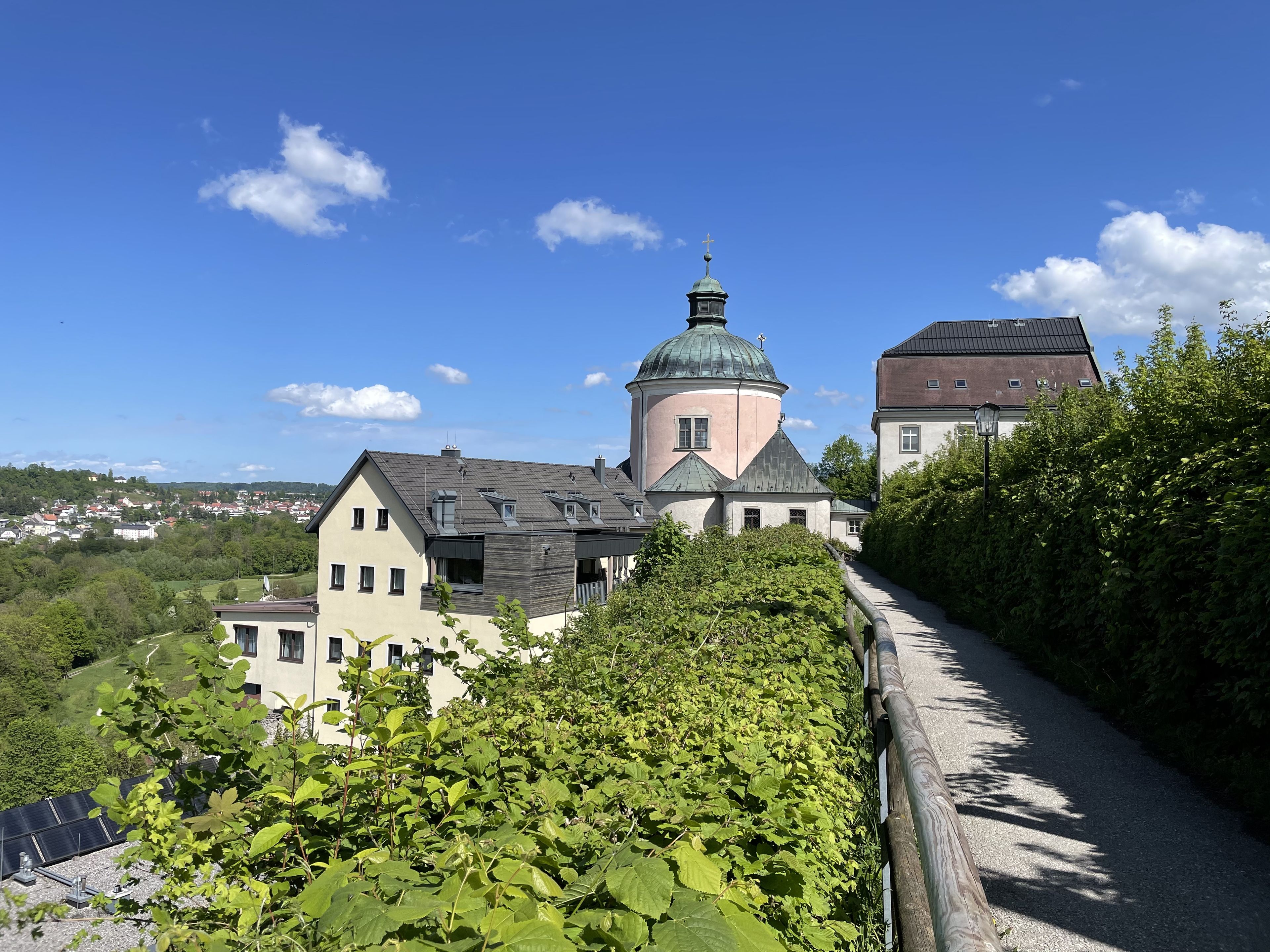 Hotel und Restaurant Christkindl vor blauem Himmel mit Stadt Steyr im Hintergrund
