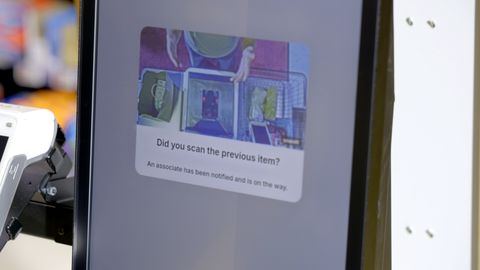 Self-checkout kiosk screen displaying "Did you scan the previous item?" alert with a store associate notification message.