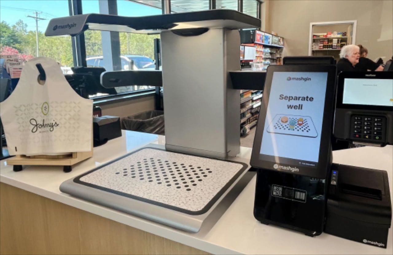 Mashgin self-checkout kiosk at Johnny's Market displaying "Separate well" prompt, with receipt printer and branded shopping bag.