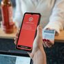 Person holding a phone displaying "Verification Failed" screen, while another holds a bottle and ID card at a counter.