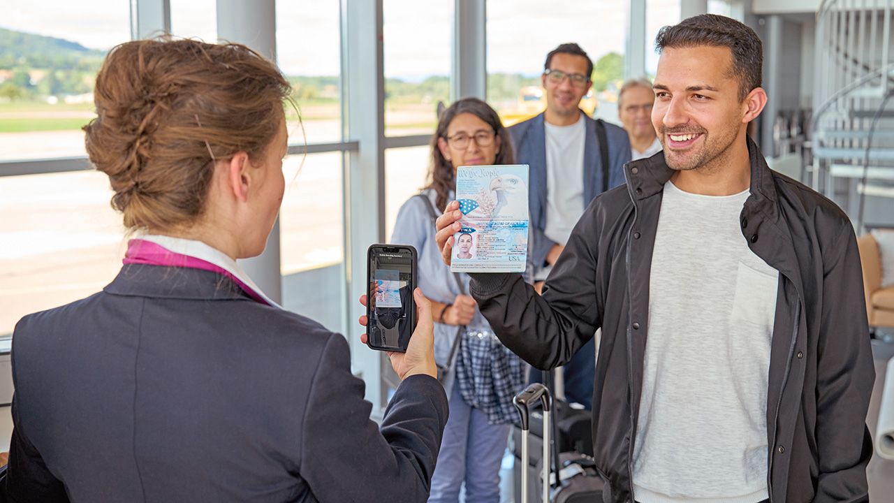 An airline passenger having their passport scanned on a mobile phone before boarding a flight