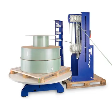 Strapping band dispenser machine with large strapping coil on pallet