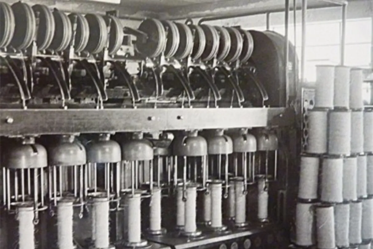 Vintage textile machinery with spools of thread, showcasing industrial innovation in fiber rope production.