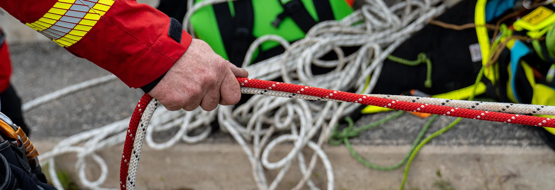 Red and white kernmmantle rope pulled by hand