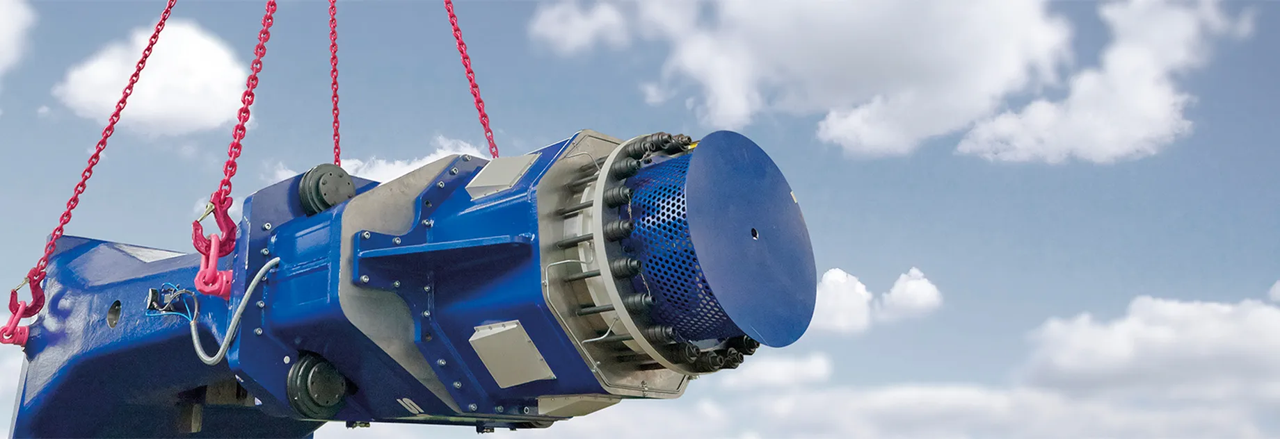 Blue heavy-duty component lifted securely with red lifting chains – durable and reliable lifting technology under open sky