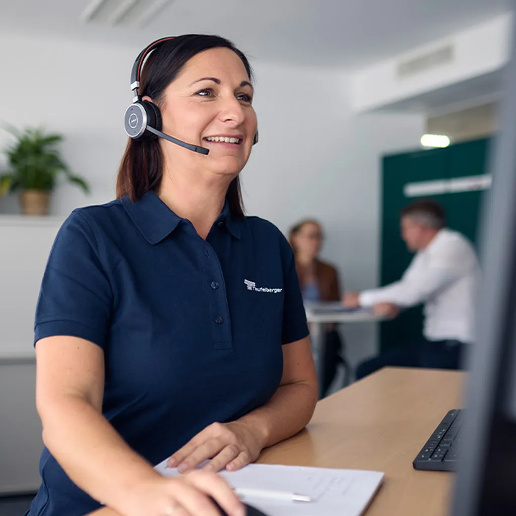 Person wearing a headset assisting customers at a modern service workstation