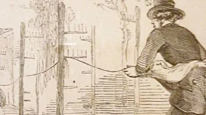 A man in 19th-century attire strings wire along wooden posts, with a wheelbarrow nearby. Trees and a fence are in the background.