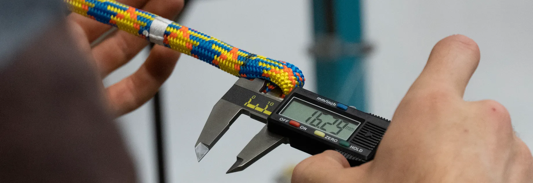 You can see two hands holding the drenaLINE rope while measuring the created splice loop with a tool