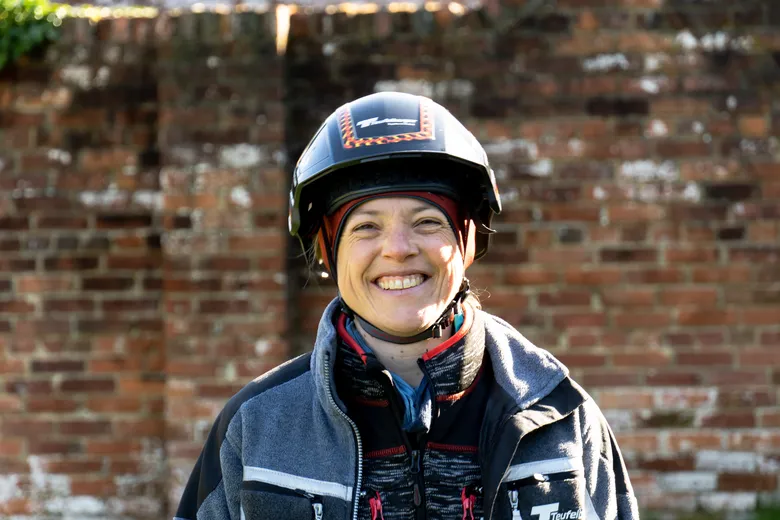 Portrait of our Ambassador Eva Maria with a brick wall in the background