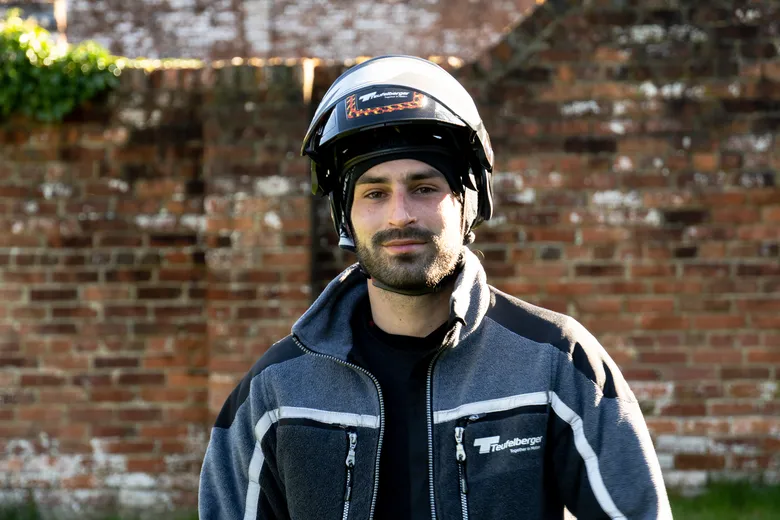 Portrait of our Ambassador Arthur wearing a Teufelberger Protos helmet in front of a brick wall