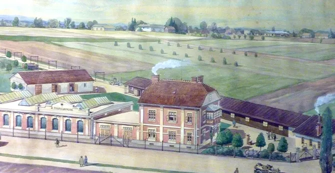 Vintage illustration of a rural factory complex with multiple buildings, surrounding fields, and distant trees under a cloudy sky.
