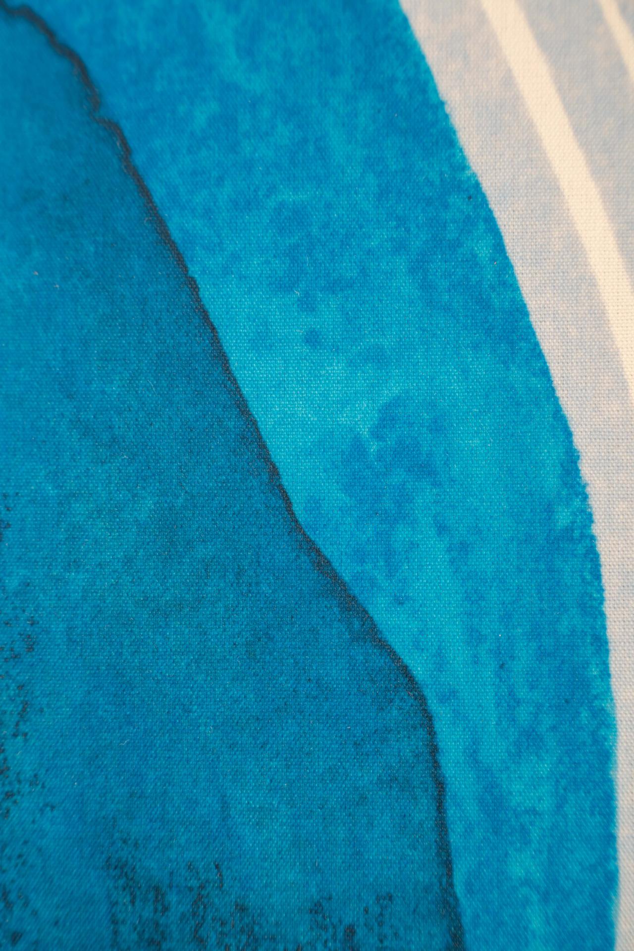 Abstract close-up of textured blue surface with a darker blue edge, resembling waves or contours, alongside light-striped patterns.