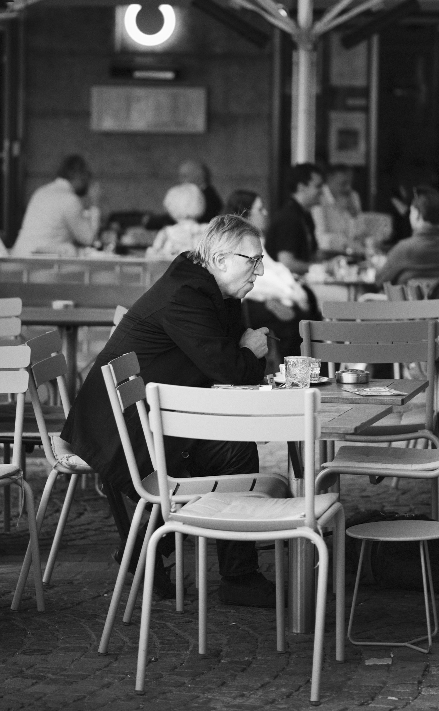 A man sits at a cafe in Vienna, Austria. Sony A7C; Sony FE 85mm f/1.8
