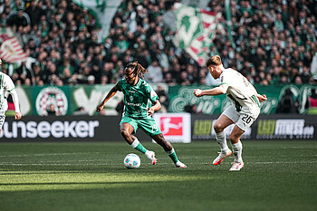 Issa Kaboré am Ball im Heimtrikot gegen Gladbach im Weserstadion bei Sonnenschein