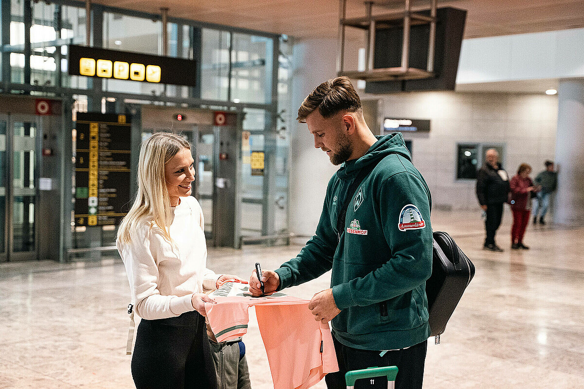 Niclas Füllkrug macht ein Foto mit den Fans. 