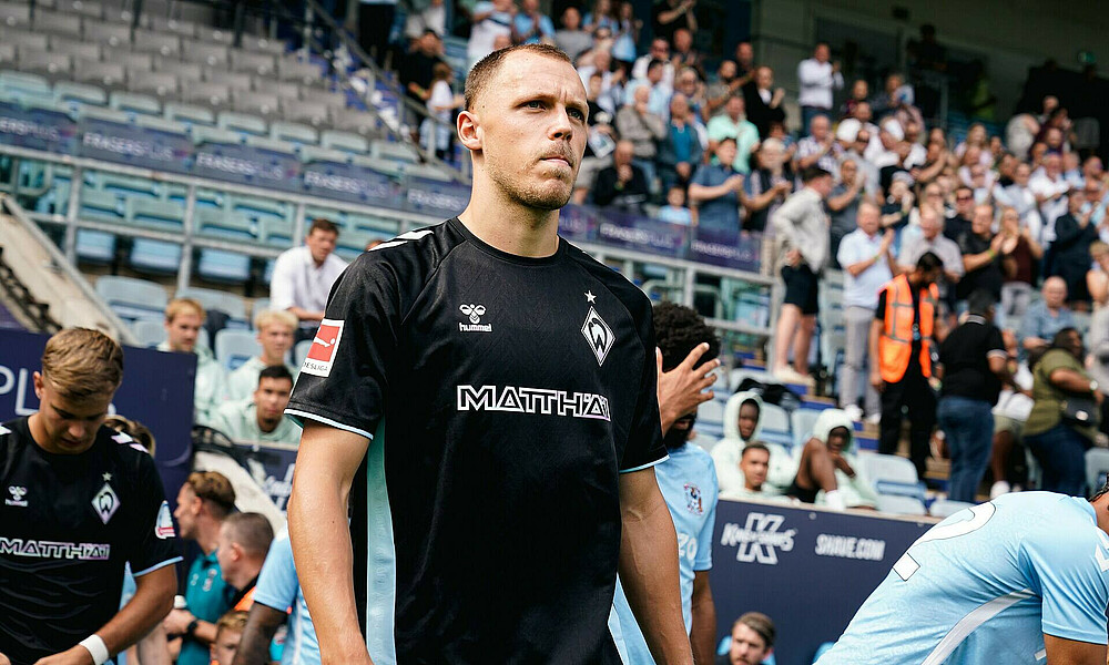Senne Lynen beim Einlaufen ins Stadion. Er trägt das schwarze Third-Trikot.