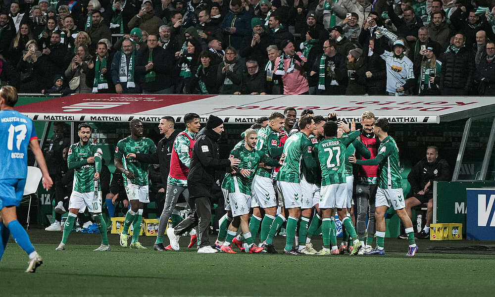 Die Werder-Spieler jubeln am Spielfeldrand.  