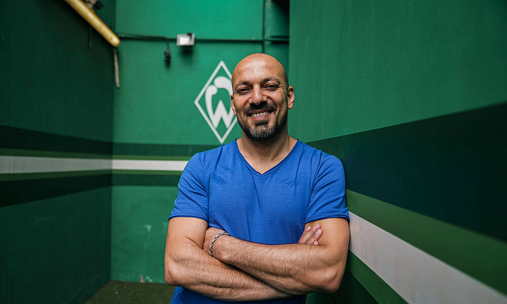 null Yasin Seiwasser lehnt an einer Wand, hinter ihm die Werder-Raute.