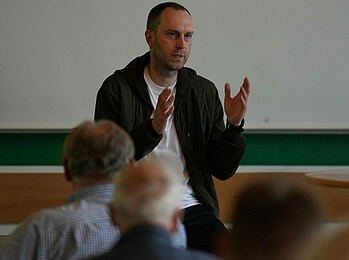 null Ole Werner gestikuliert vor Zuhörern.