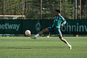 null Felix Agu spielt einen Ball mit gestrecktem Bein.
