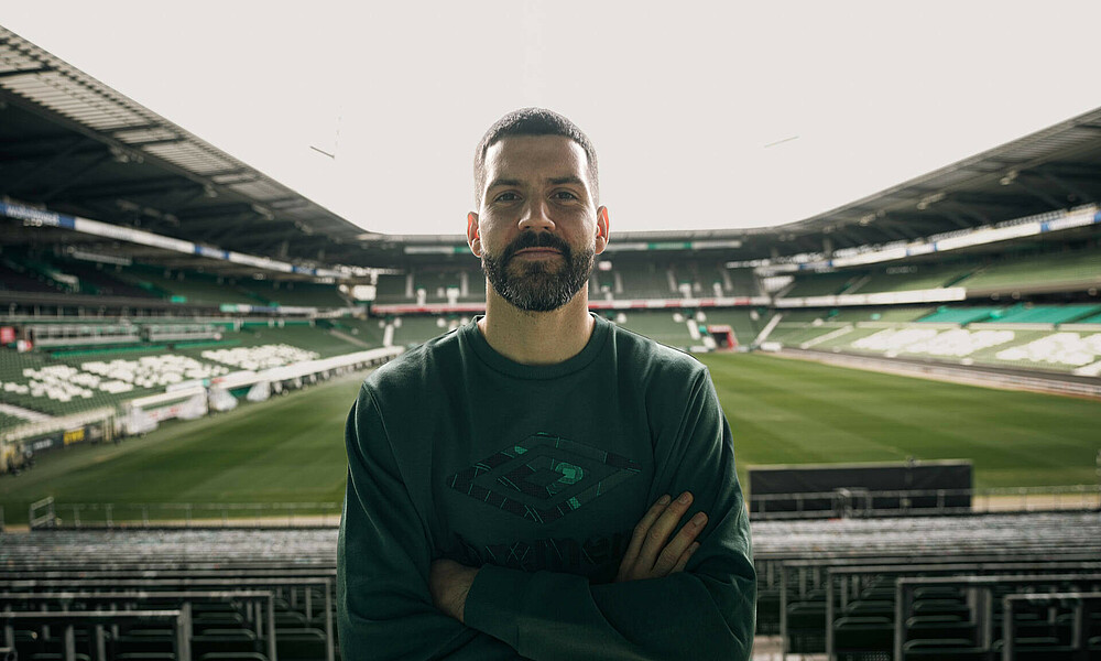 Jung steht in der Ostkurve, im Hintergrund das wohninvest WESERSTADION. 