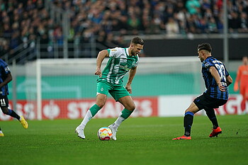 Niclas Füllkrug läuft mit dem Ball am Fuß auf einen Paderborner Spieler zu.