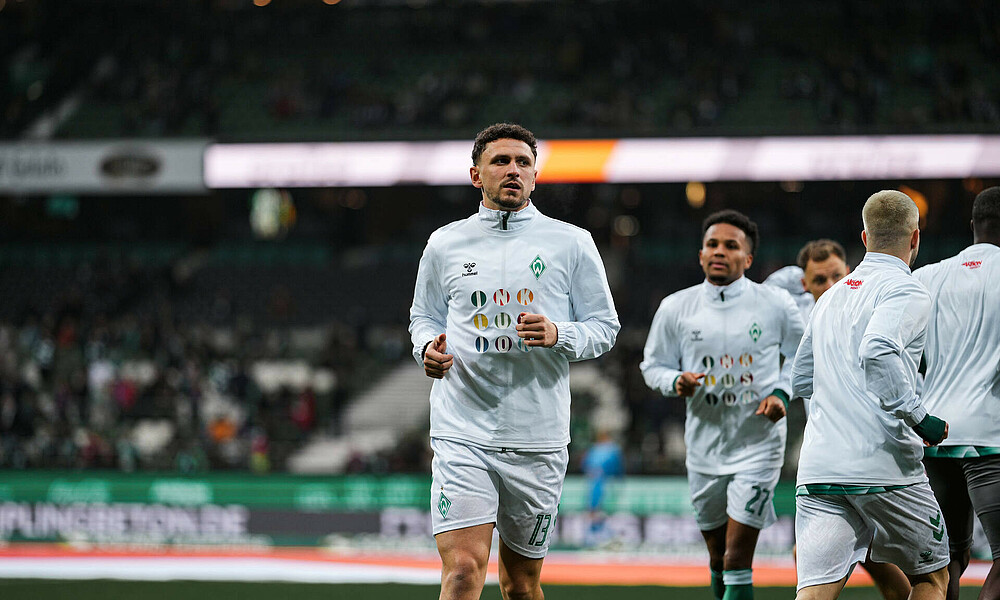 Veljković, Agu und weitere Spieler wärmen sich in den Inklusions Warm-Up Shirts auf. 