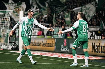 Mitchell Weiser klatscht sich vor einer Ecke mit Marvin Ducksch ab.