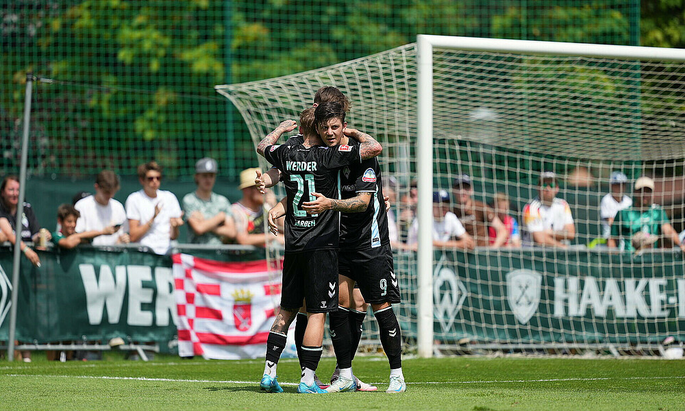 Dawid Kownacki wird von seinen Mitspielern umarmt. 