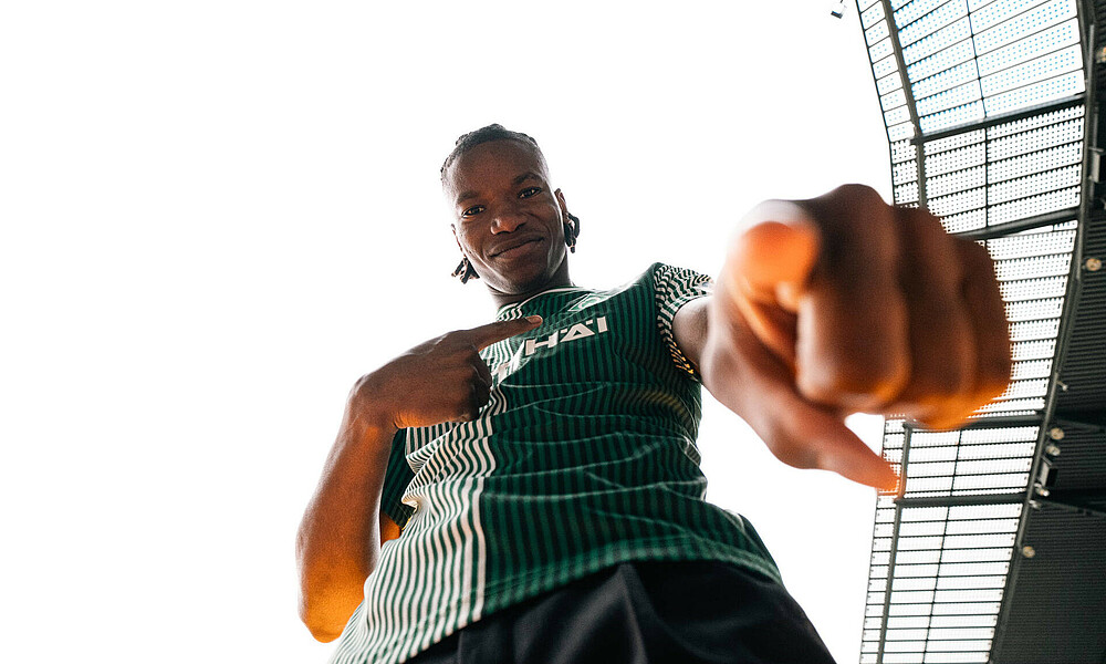 Skelly Alvero von unten fotografiert. Er trägt das Hometrikot. Mit dem Zeigefinger zeigt er in die Kamera.