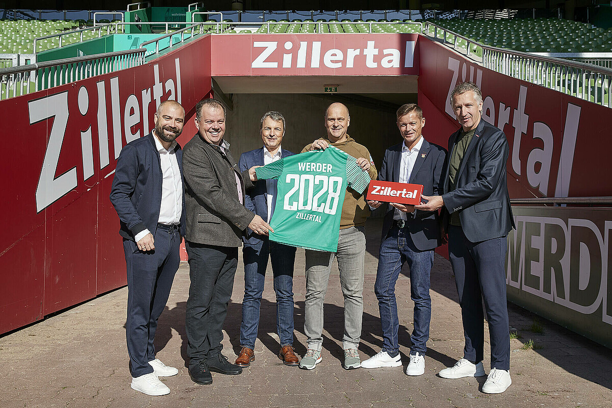 Christian Rauhut, Vertreter des Zillertals, Klaus Filbry und FRank Baumann halten ein Trikot hoch auf dem 2028 steht.