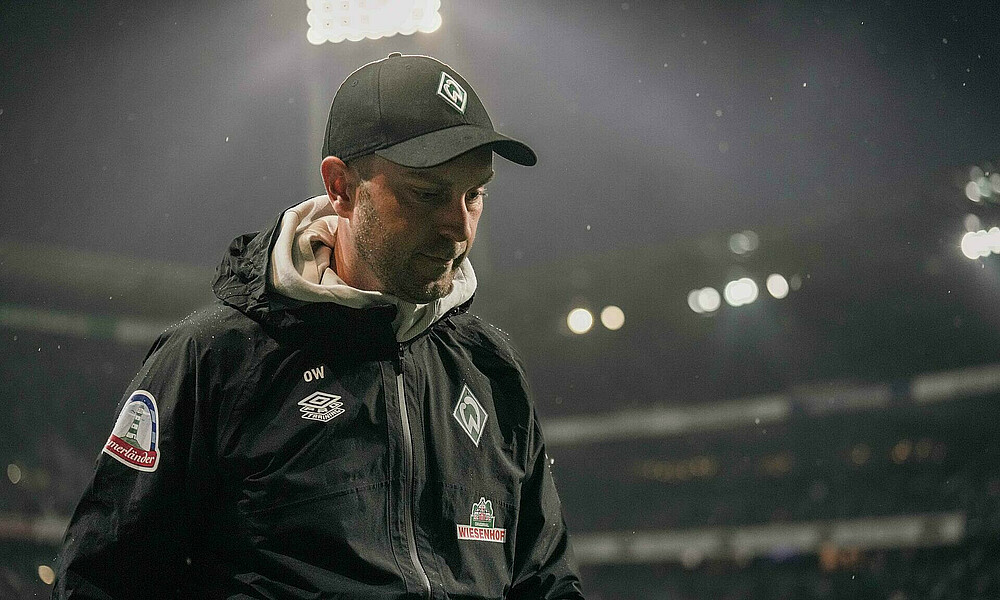 Ole Werner mit gesenktem Kopf bei einem Flutlichtspiel.