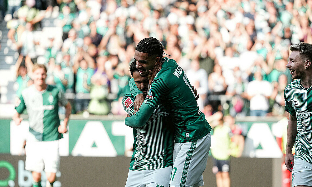 null Justin Njinmah und Leonardo Bittencourt umarmen sich.